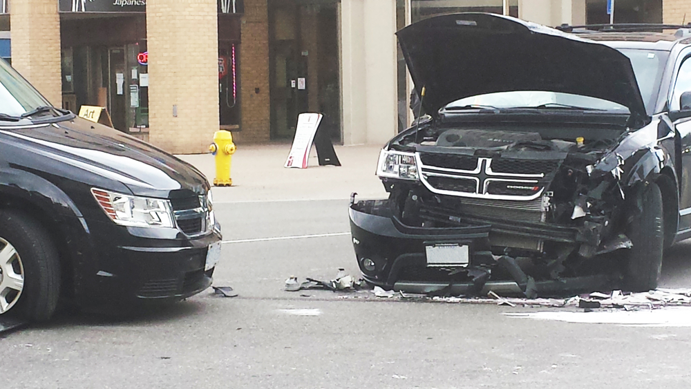 New Brunswick, Canada - May 03: two destroyed vehicle accident in a crash in the middle of the street as editorial